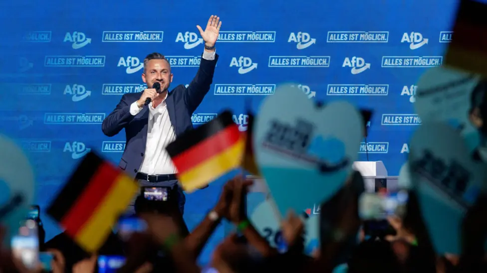 AfD supporters wave German and party flags at a rally ahead of the Saxony-Anhalt state election