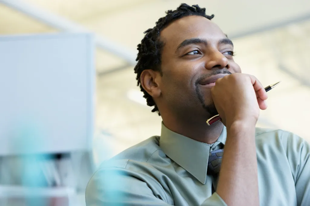 An office worker pausing thoughtfully at his desk, reflecting workplace habits around AI tool use