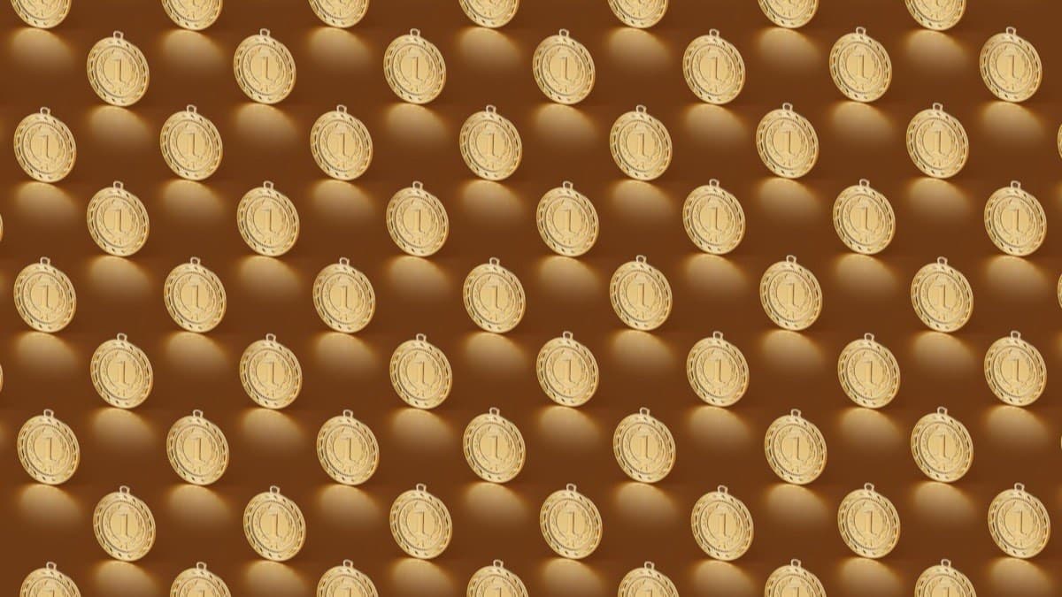 A repeating pattern of gold first place medals on a warm background