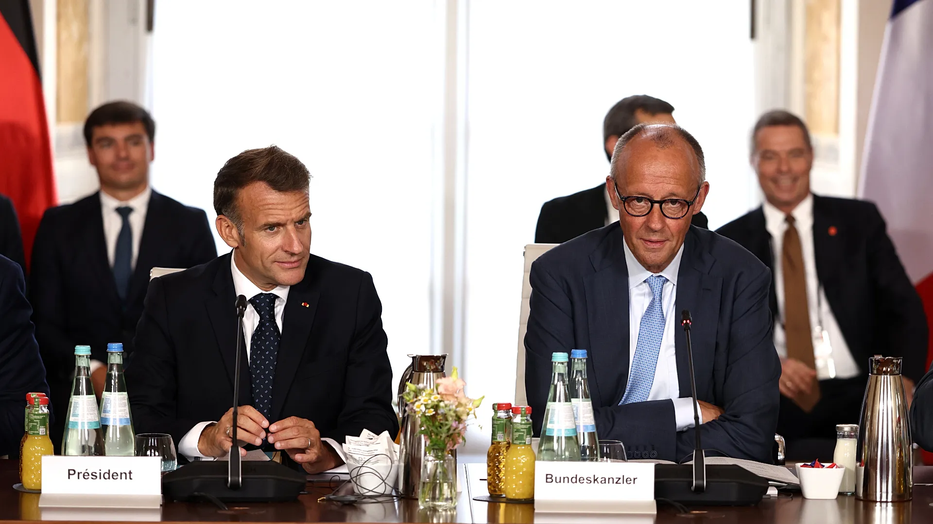 French President Emmanuel Macron and German Chancellor Friedrich Merz seated side by side at a joint meeting table