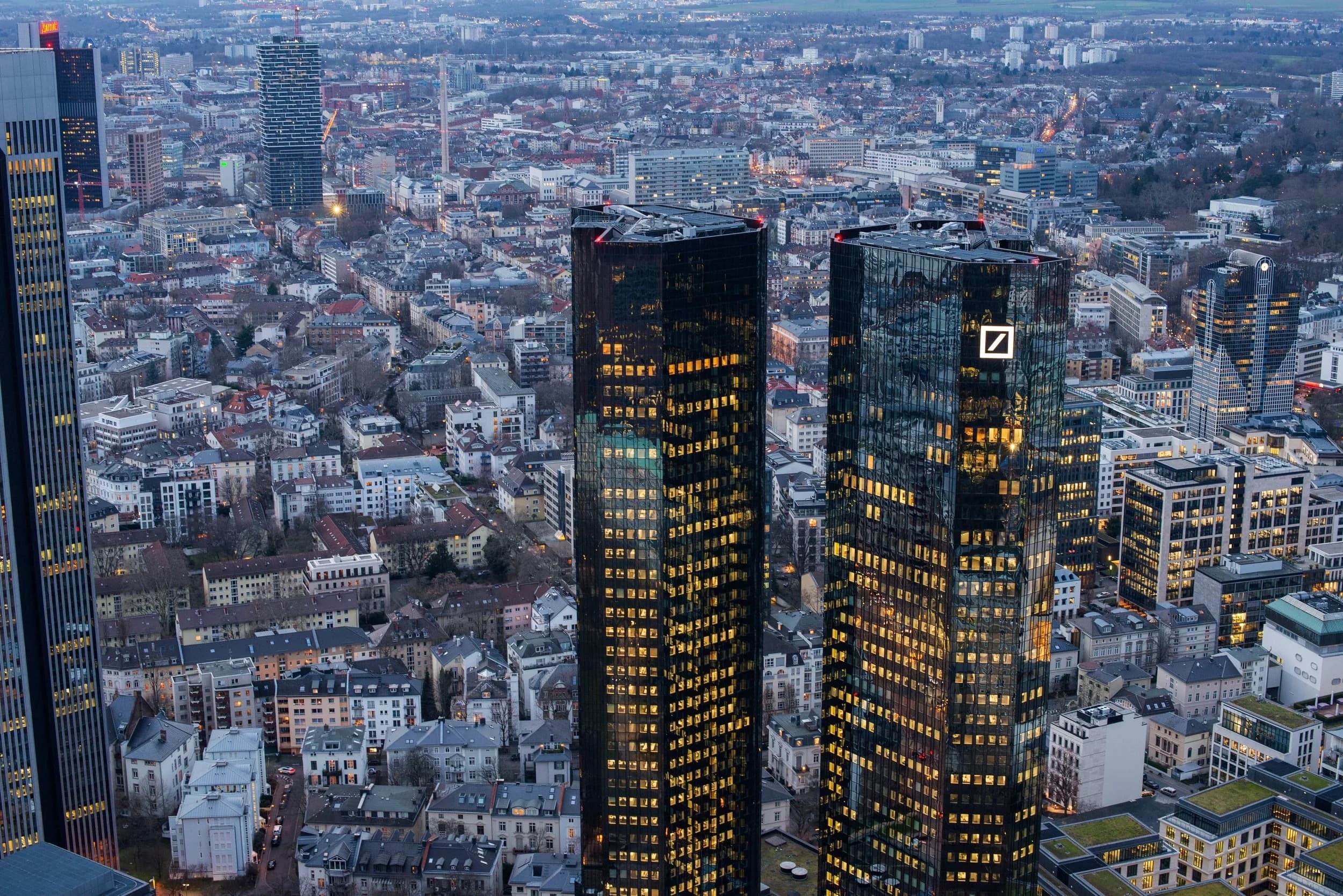 Aerial view of the Frankfurt skyline at dusk with the Deutsche Bank twin towers lit up