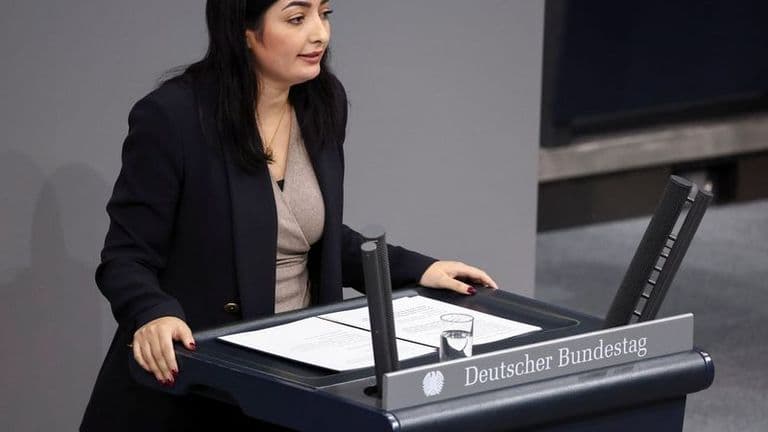 A German lawmaker speaking at a lectern in the Bundestag chamber