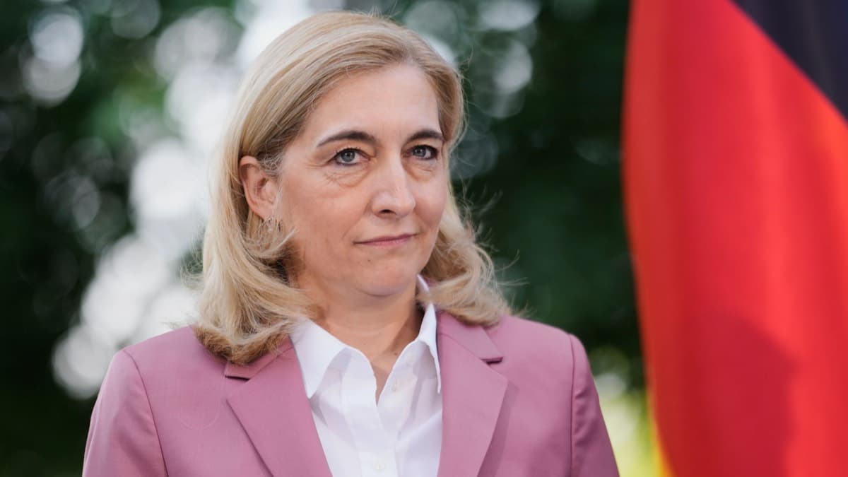 A German official standing beside the national flag
