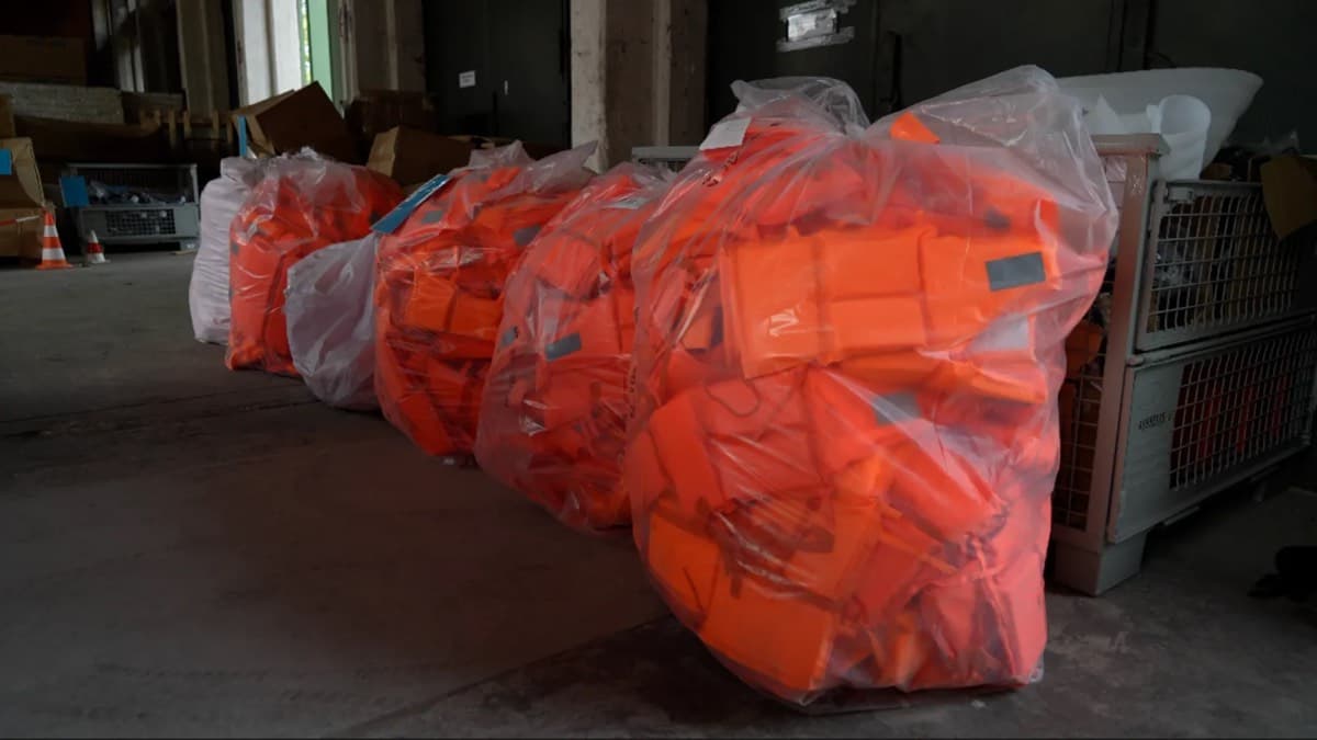 Bags of orange life jackets seized and stored in a warehouse