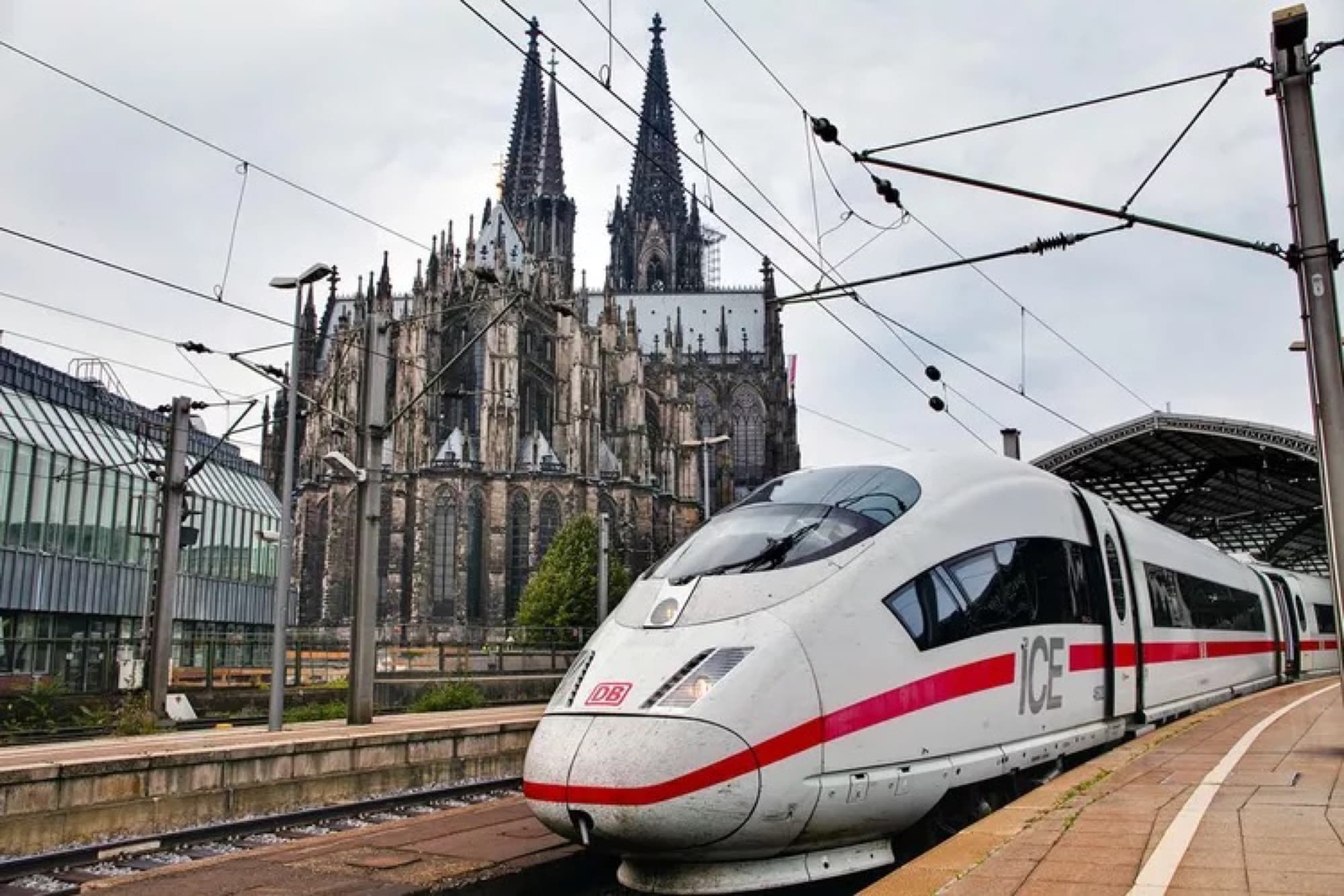 A Deutsche Bahn ICE high speed train at a platform with Cologne Cathedral behind it