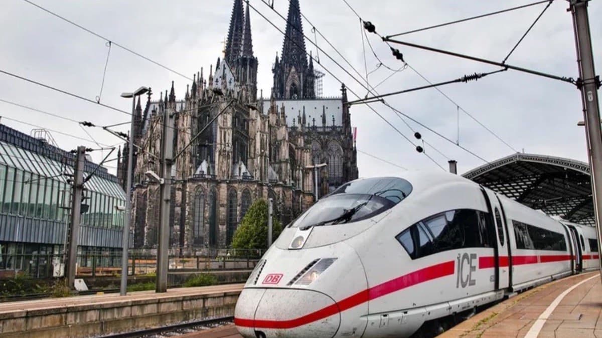 A Deutsche Bahn ICE high speed train at a platform with Cologne Cathedral behind it