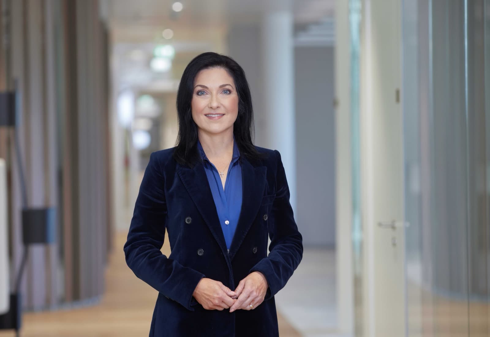 Katherina Reiche, Germany's economy minister, in a dark velvet blazer in an office corridor