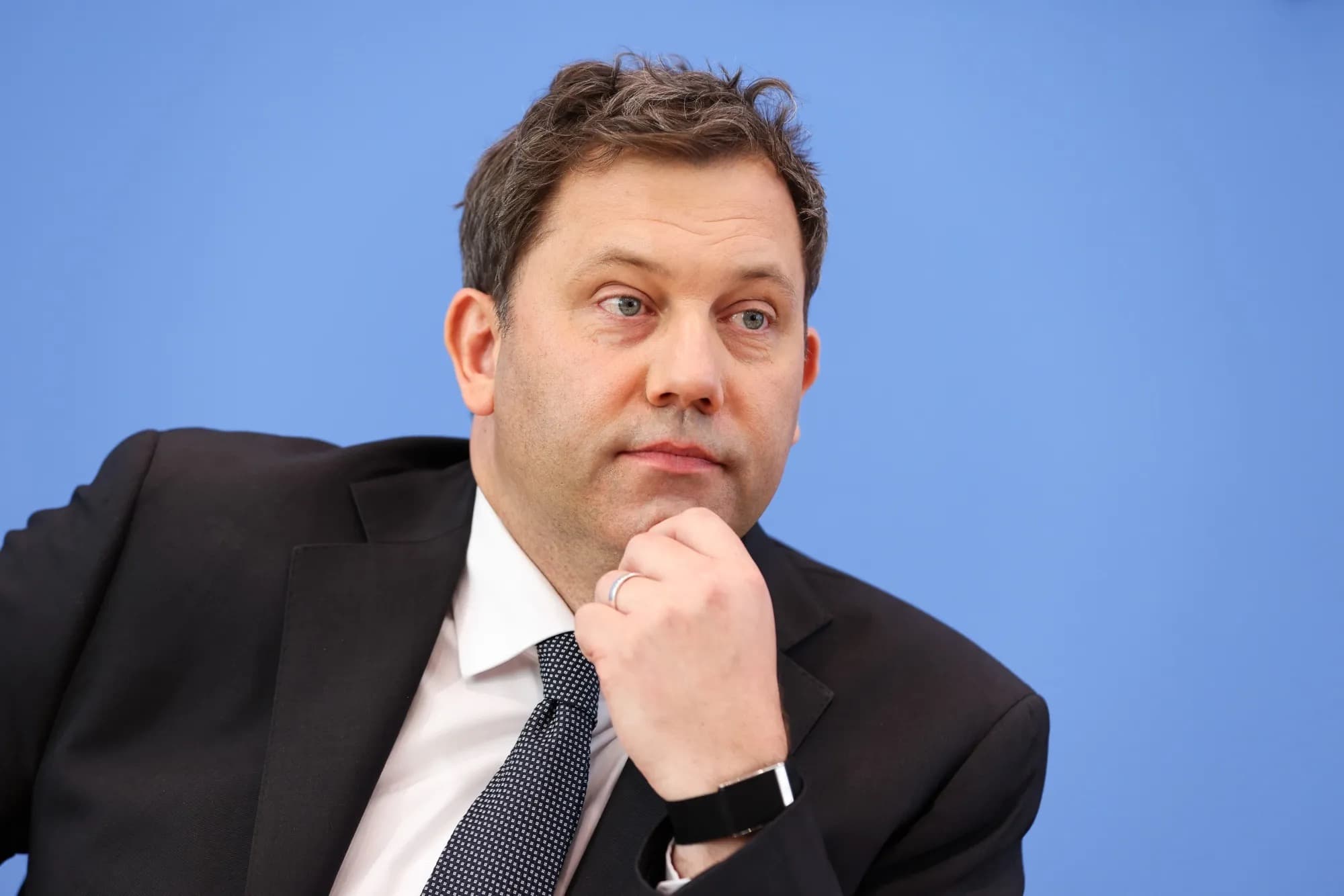 German Finance Minister Lars Klingbeil resting his chin on his hand at a press conference