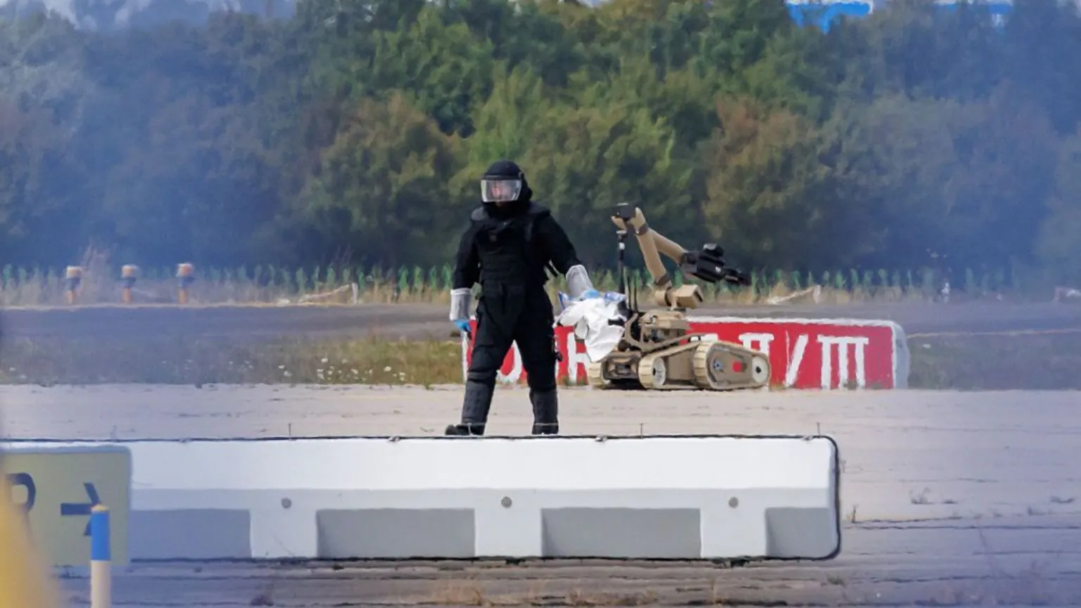 A bomb disposal officer and robot on the tarmac at Leipzig Halle Airport during the overnight security operation