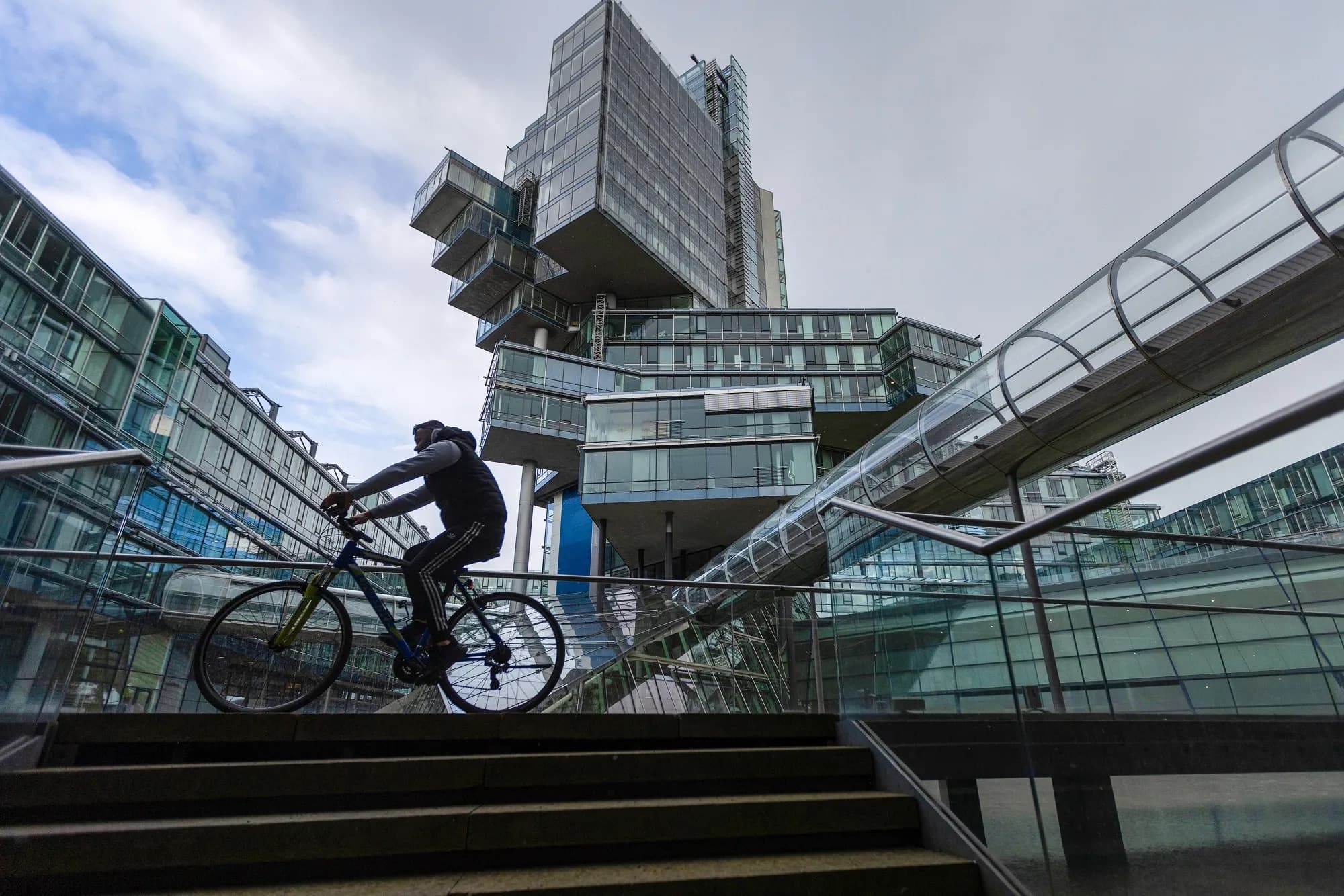 A cyclist passing the NordLB headquarters tower in Hannover, Germany