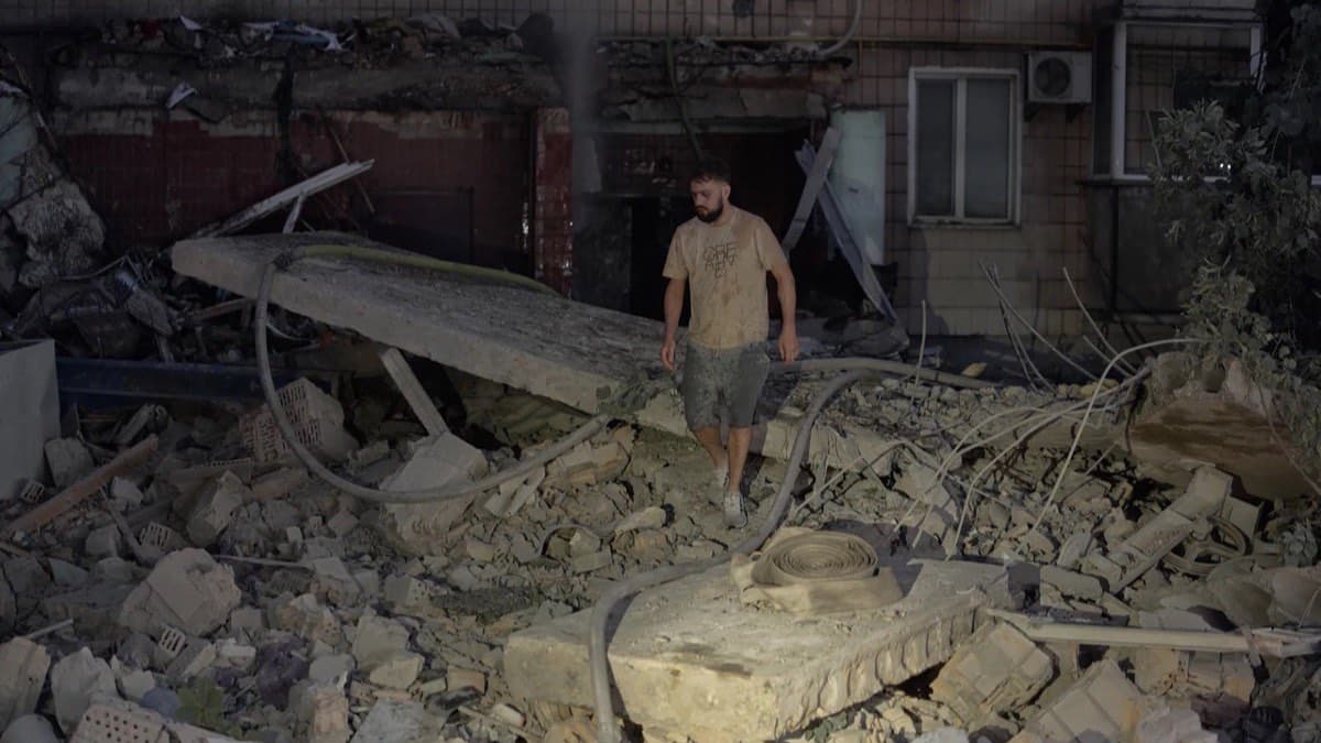 A man walks through the rubble of a residential building in Kyiv destroyed by a Russian strike