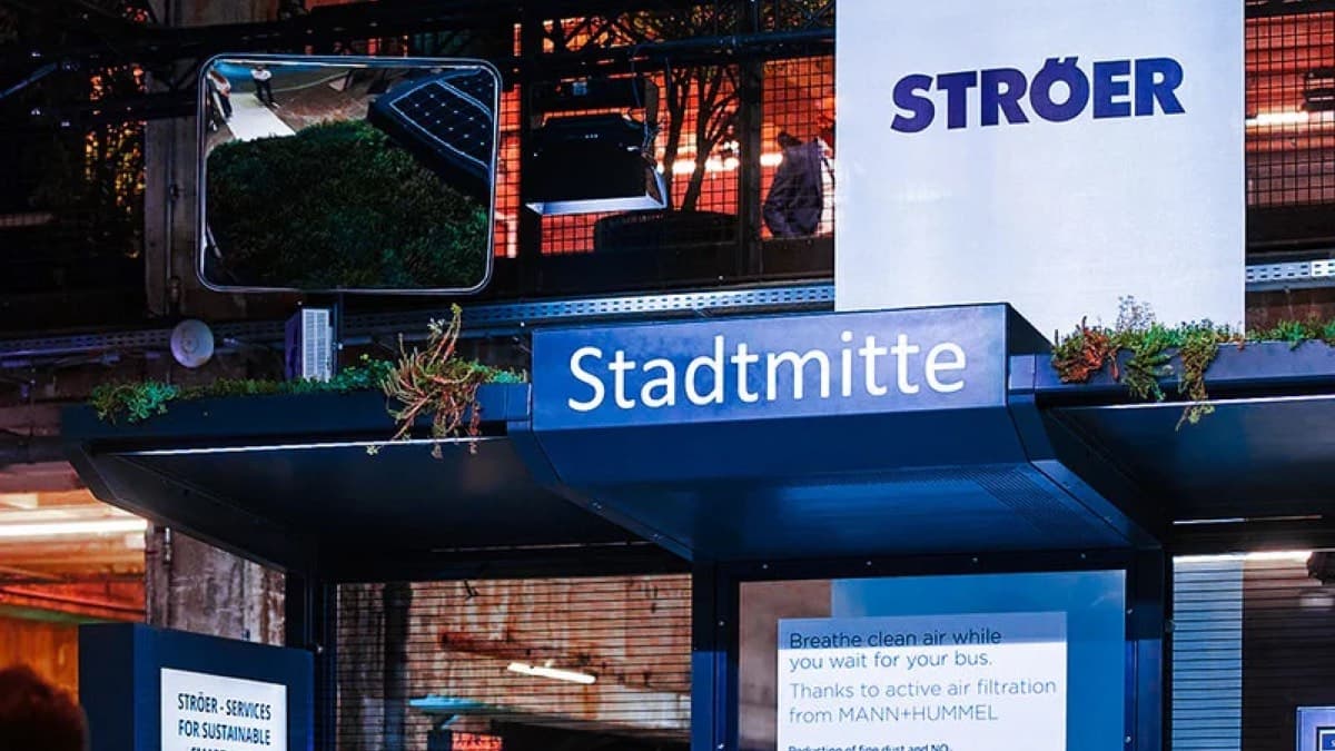 A Ströer digital advertising bus stop branded Stadtmitte on a city street at night