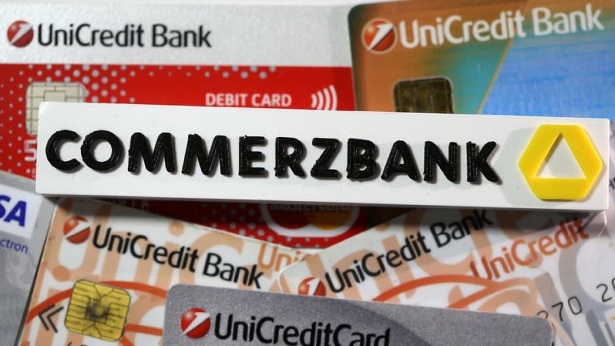 A Commerzbank sign resting on a spread of UniCredit bank payment cards
