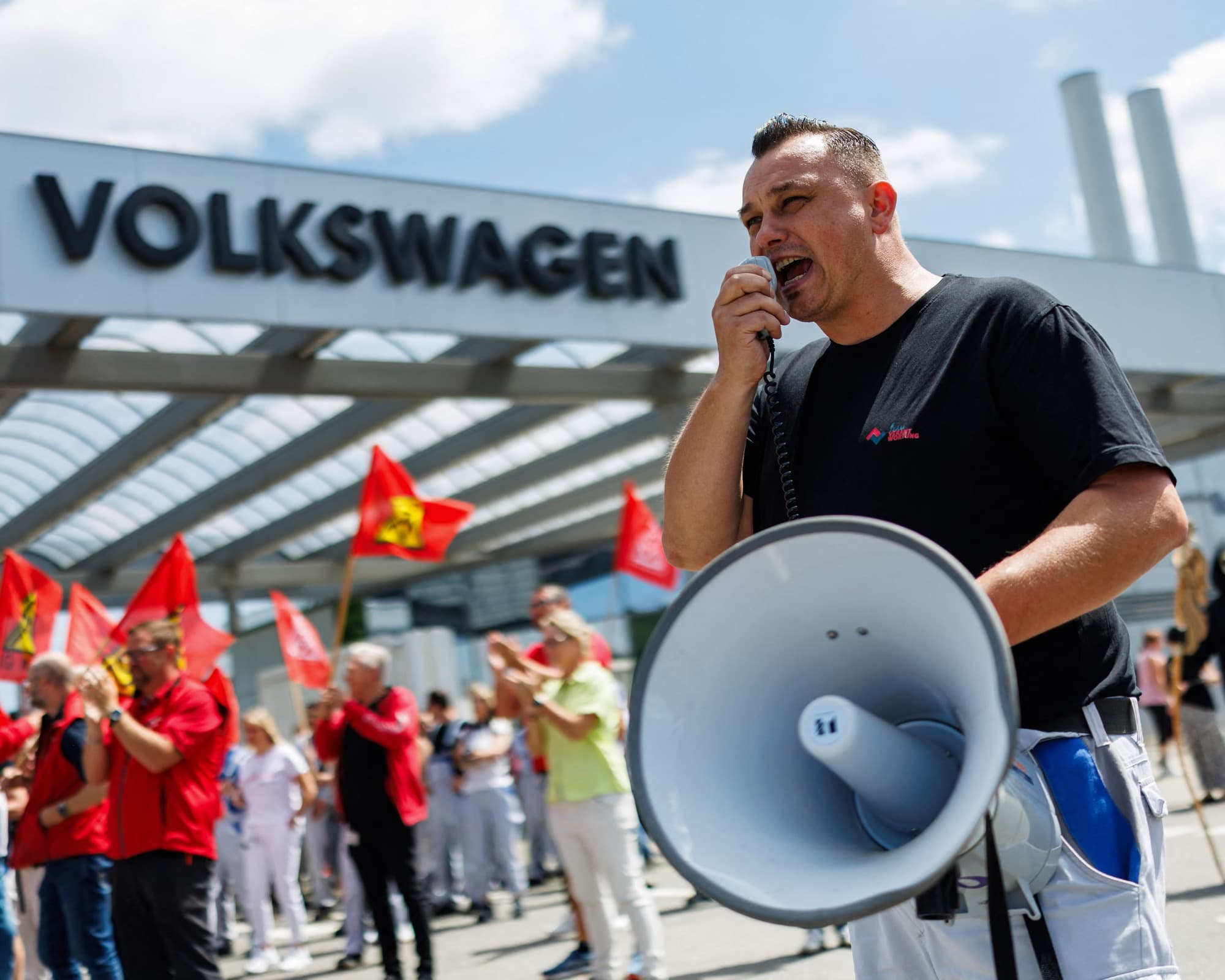 Volkswagen workers protesting with red union flags against proposed job cuts and plant closures