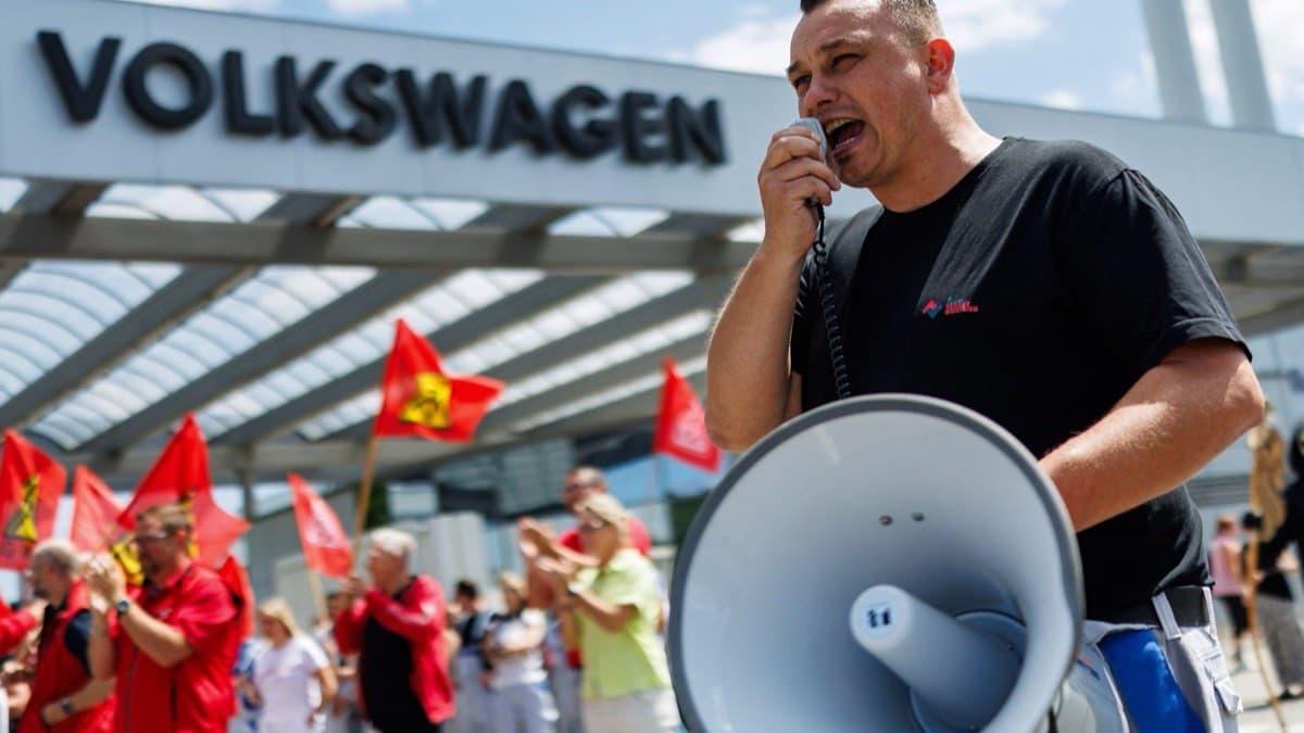 Volkswagen workers protesting with red union flags against proposed job cuts and plant closures