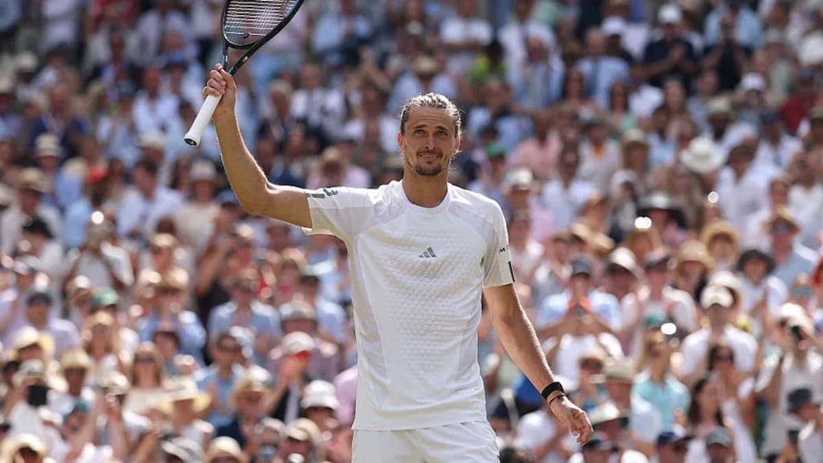Alexander Zverev raises his racket to the Wimbledon crowd after a win