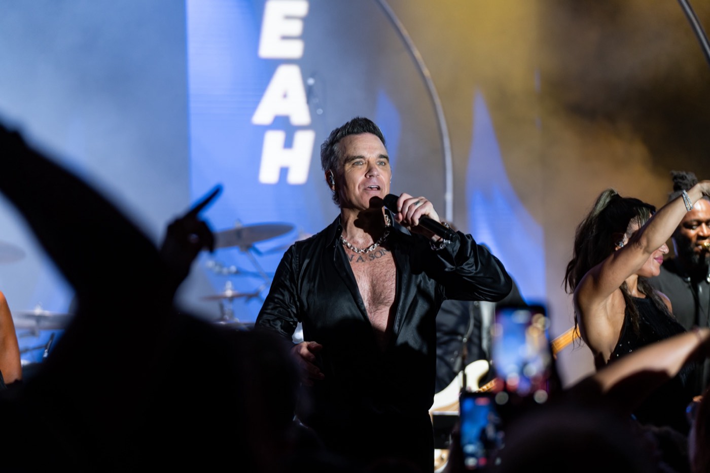 Robbie Williams singing during his headline performance at BIG ART Festival